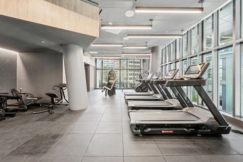 A gym with treadmills and a person walking.