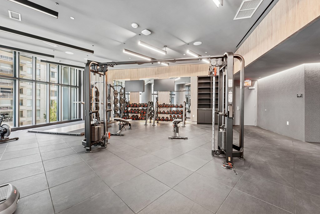 A gym with a variety of equipment including treadmills, weights, and exercise machines.