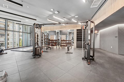 A gym with a variety of equipment including treadmills, weights, and exercise machines.