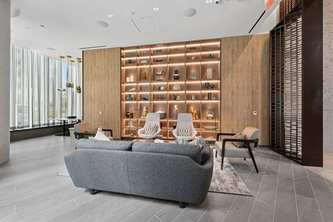 A modern living room with a grey sofa and a wooden cabinet with shelves.