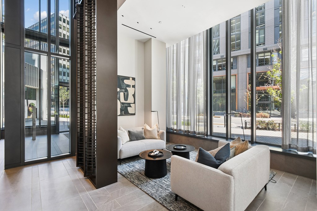 A modern living room with a large window and a white couch.