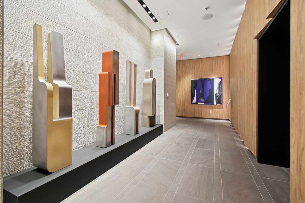 A hallway with a series of metallic sculptures on display.