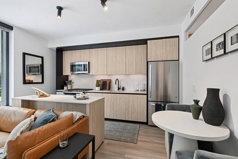 A modern kitchen with a refrigerator, microwave, and oven.