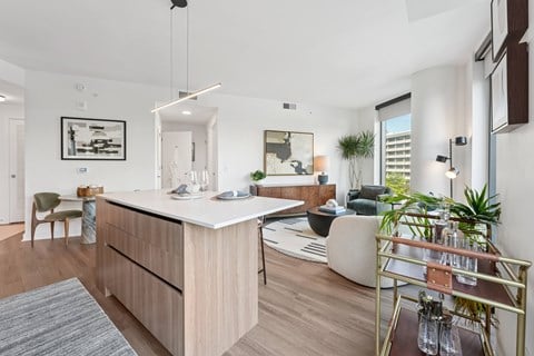 A modern kitchen with a white countertop and wooden cabinets.