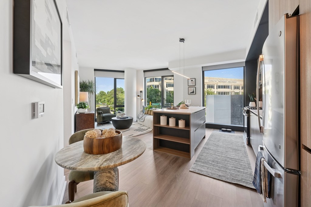 A modern kitchen with a table and chairs in the foreground.