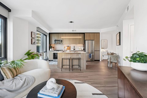 A modern kitchen with a breakfast bar and a dining table with chairs.