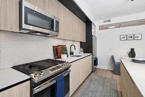 A modern kitchen with a stove top oven and microwave above it.