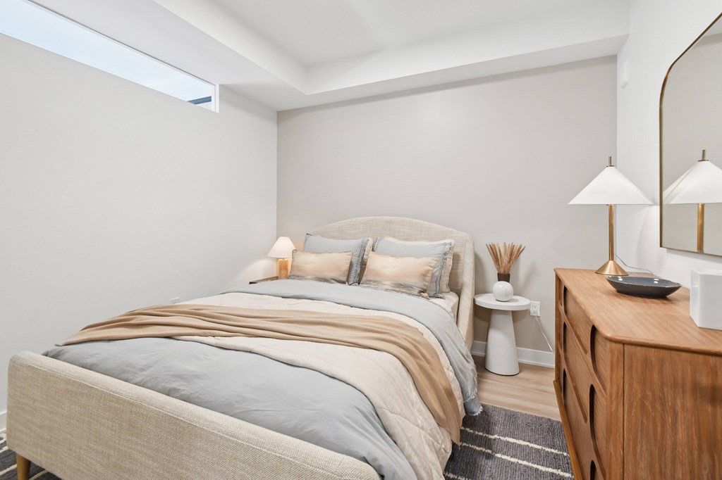 A bedroom with a bed, nightstand, and lamp.