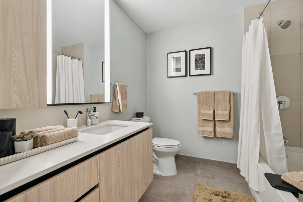 A bathroom with a toilet, sink, and shower.