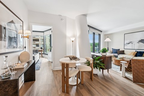 A modern living room with a dining area and a kitchen in the background.