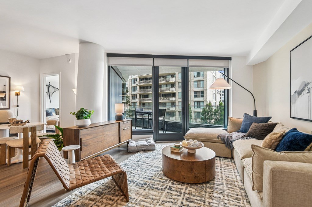 A modern living room with a wooden chair and a large window.