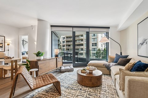 A modern living room with a wooden chair and a large window.