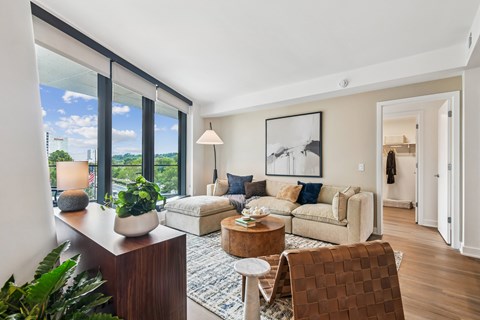 A living room with a large window and a view of a city skyline.