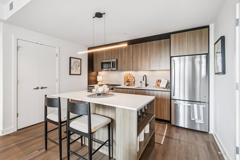 A modern kitchen with a white island and wooden cabinets.