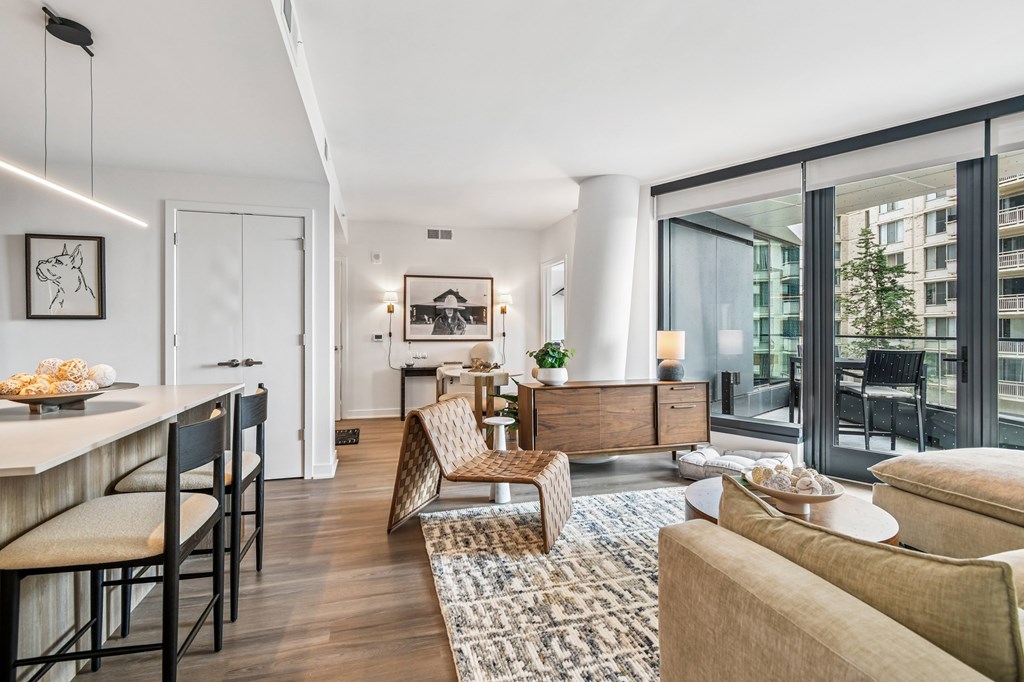 A modern living room with a dining area and a view of a building outside.