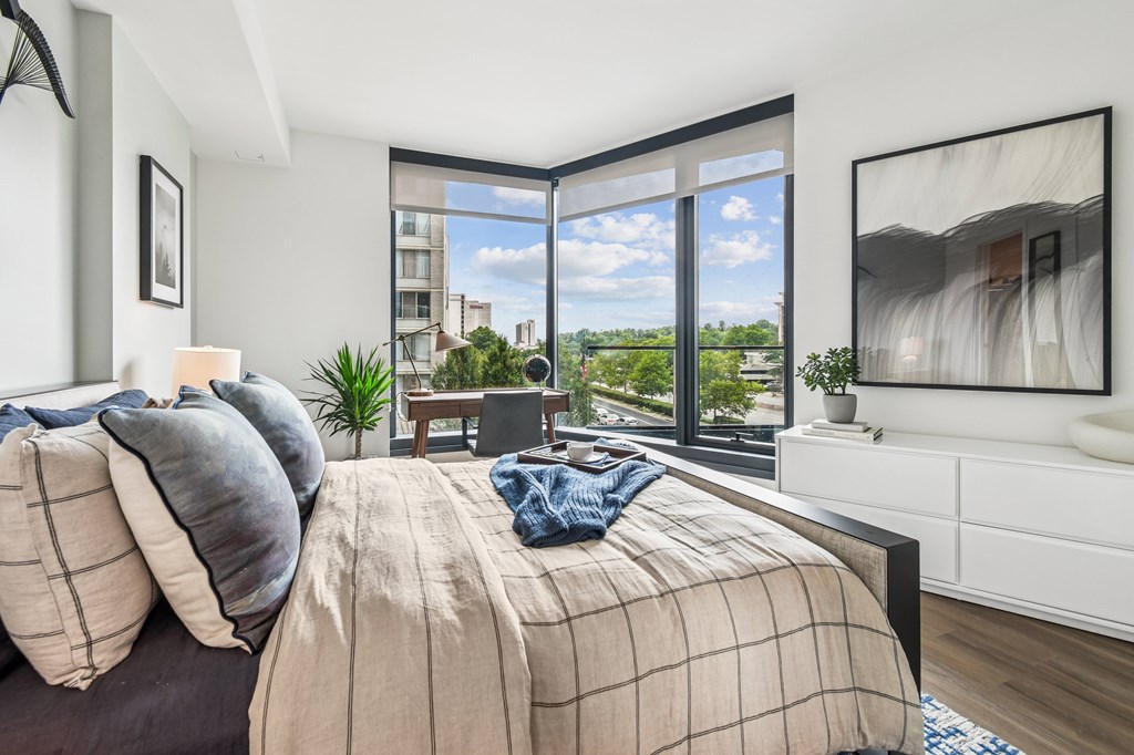 A bedroom with a large bed and a view of the city.