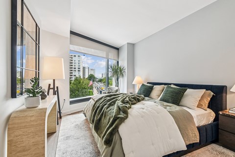 A bedroom with a large bed and a view of the city.