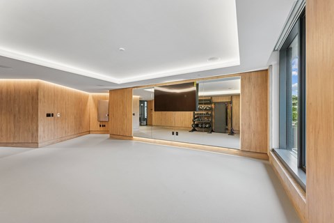 A spacious room with wooden walls and a large mirror on the wall.