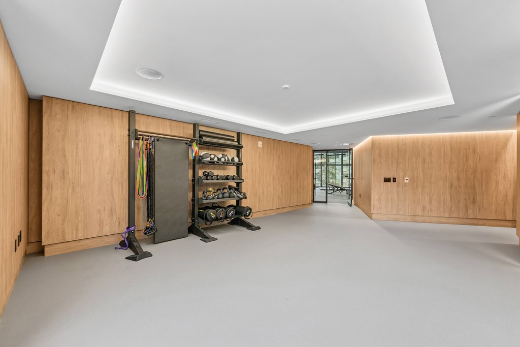 A room with wooden walls and a white ceiling has a shoe rack and a pair of shoes on the floor.