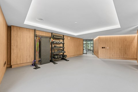 A room with wooden walls and a white ceiling has a shoe rack and a pair of shoes on the floor.