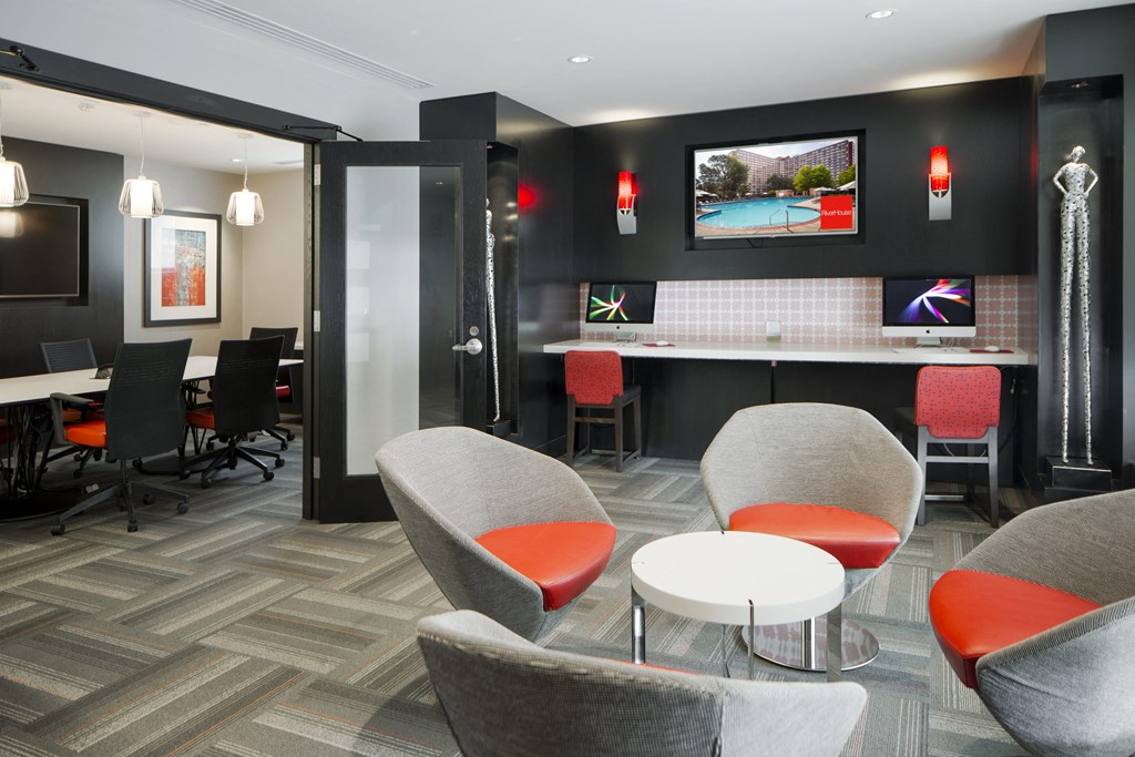 a lounge area with chairs and tables and a television