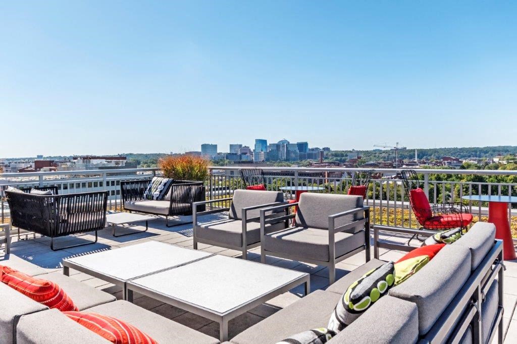 a roof deck with furniture and a view of the city