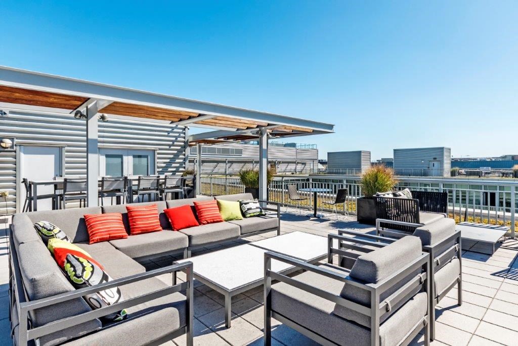 a roof deck with couches and chairs and a table