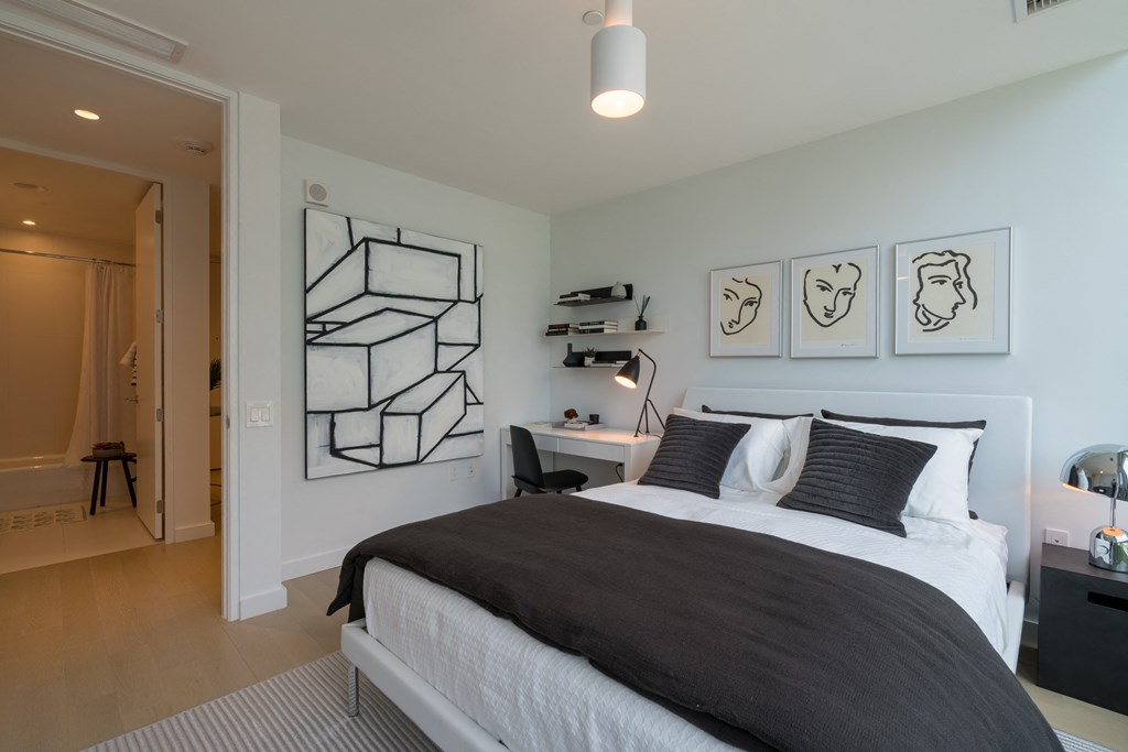 a bedroom with a bed and paintings on the wall