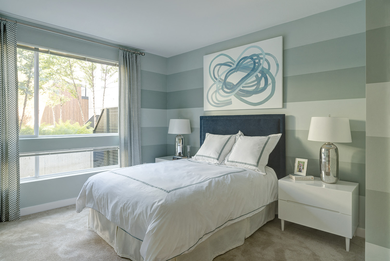 a bedroom with a bed and a large window