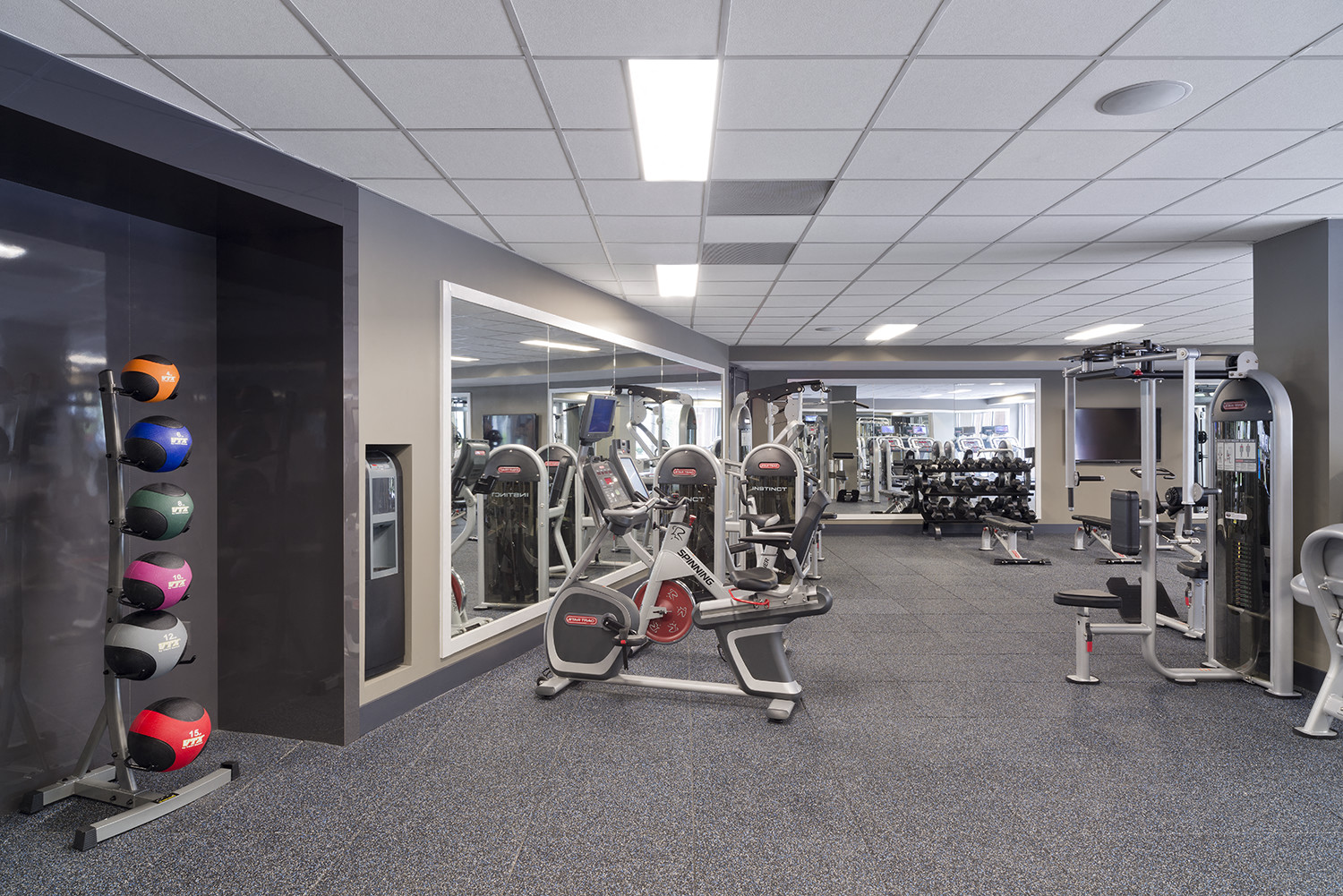 a fitness room with exercise equipment and mirrors in a building