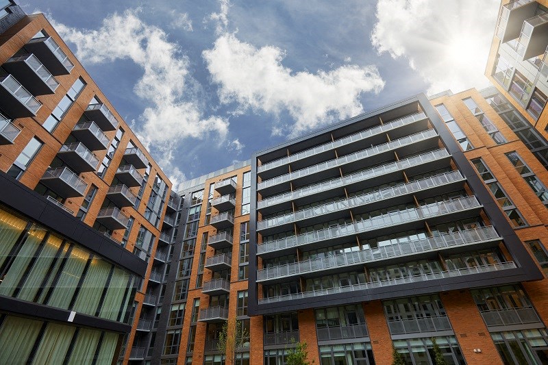 a group of apartment buildings with the sky in the background