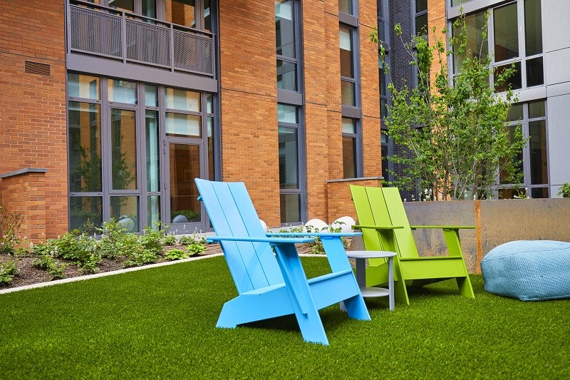 two blue and green chairs and a table on a lawn