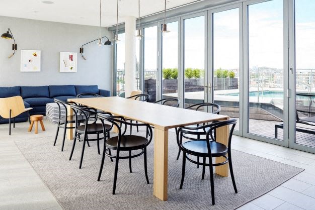 a large table and chairs in a room with windows