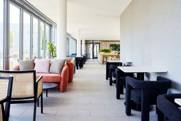 the lobby of a hotel with tables and chairs