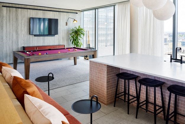 a living room with a pool table and a bar
