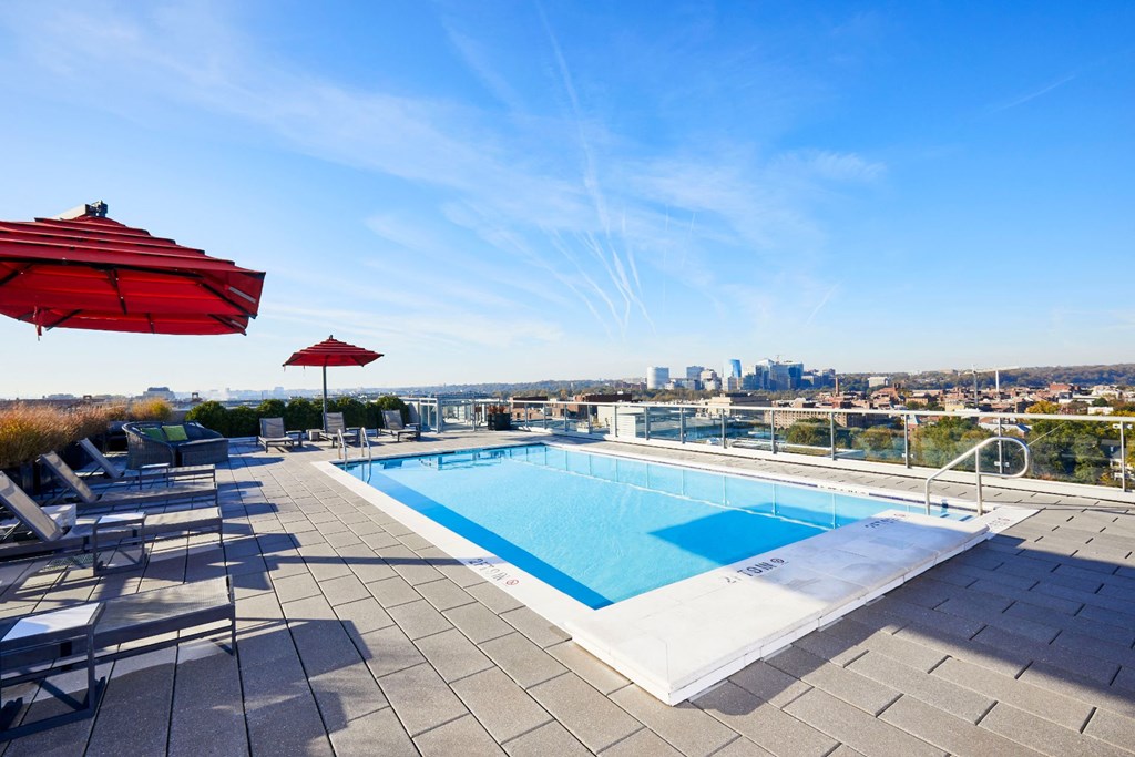 a swimming pool on the roof of a building with a city in the background