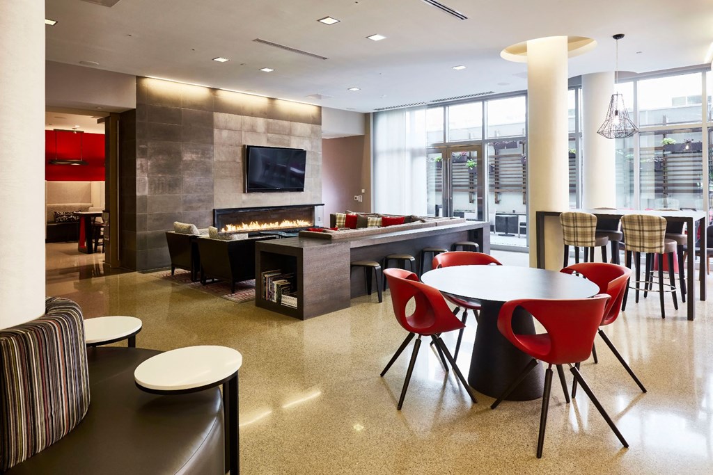 a lounge area with tables and chairs and a fireplace