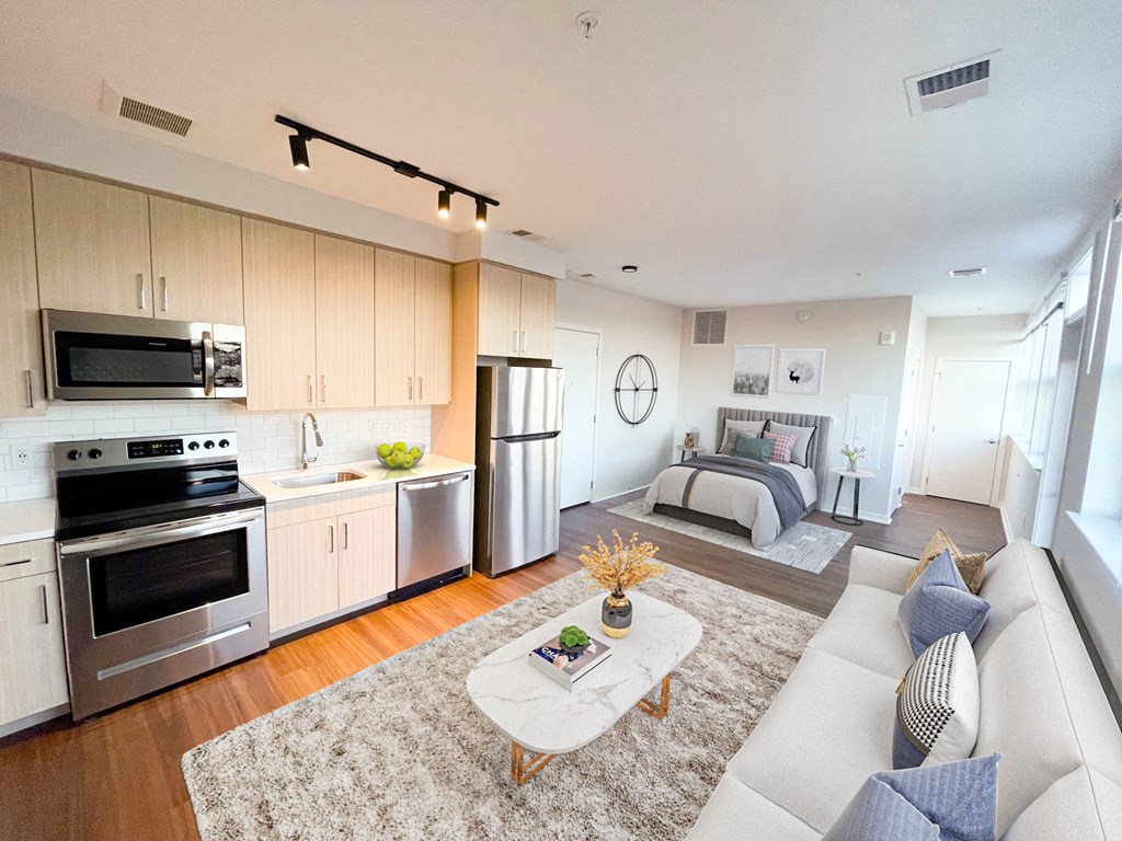 a white living room with a kitchen and a bed