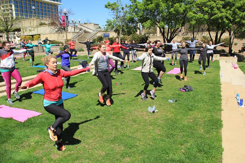 a group of people doing yoga in a park