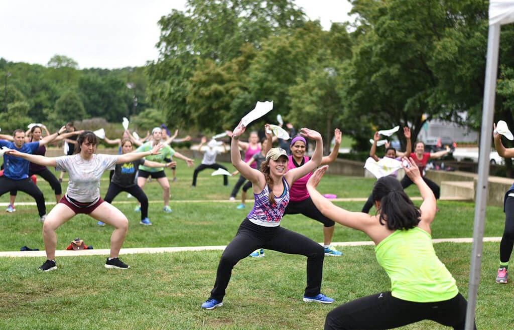 a group of women doing yoga in the park
