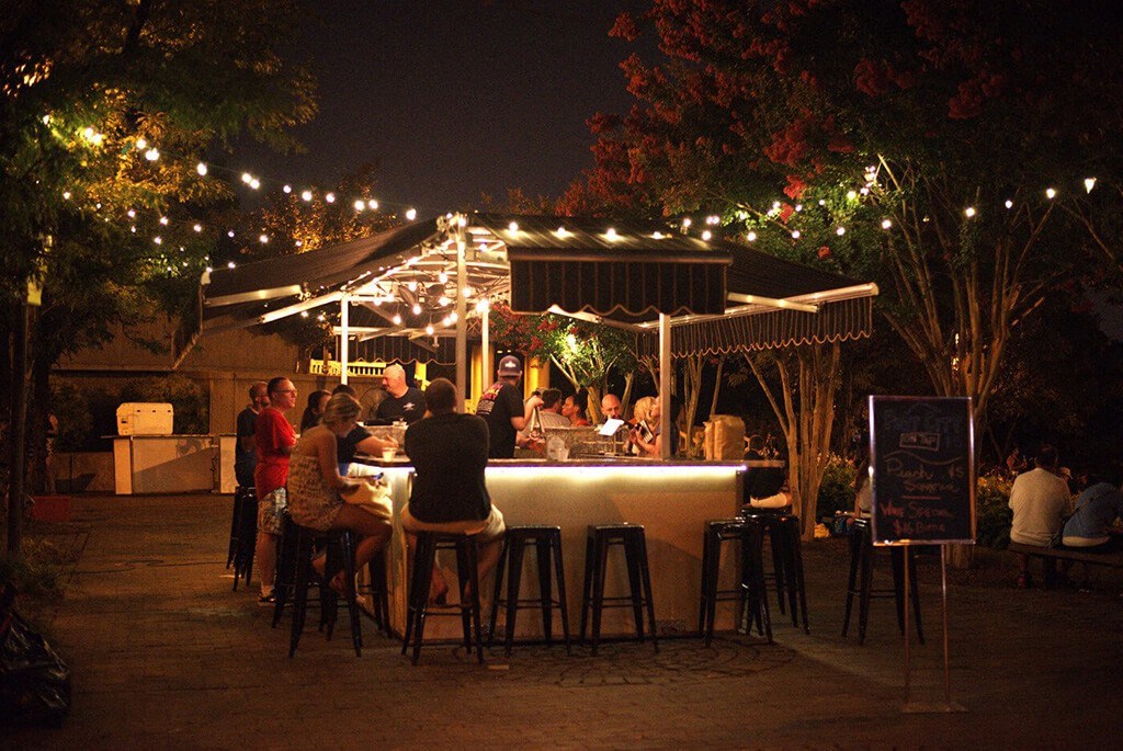 a group of people sitting at a bar at night