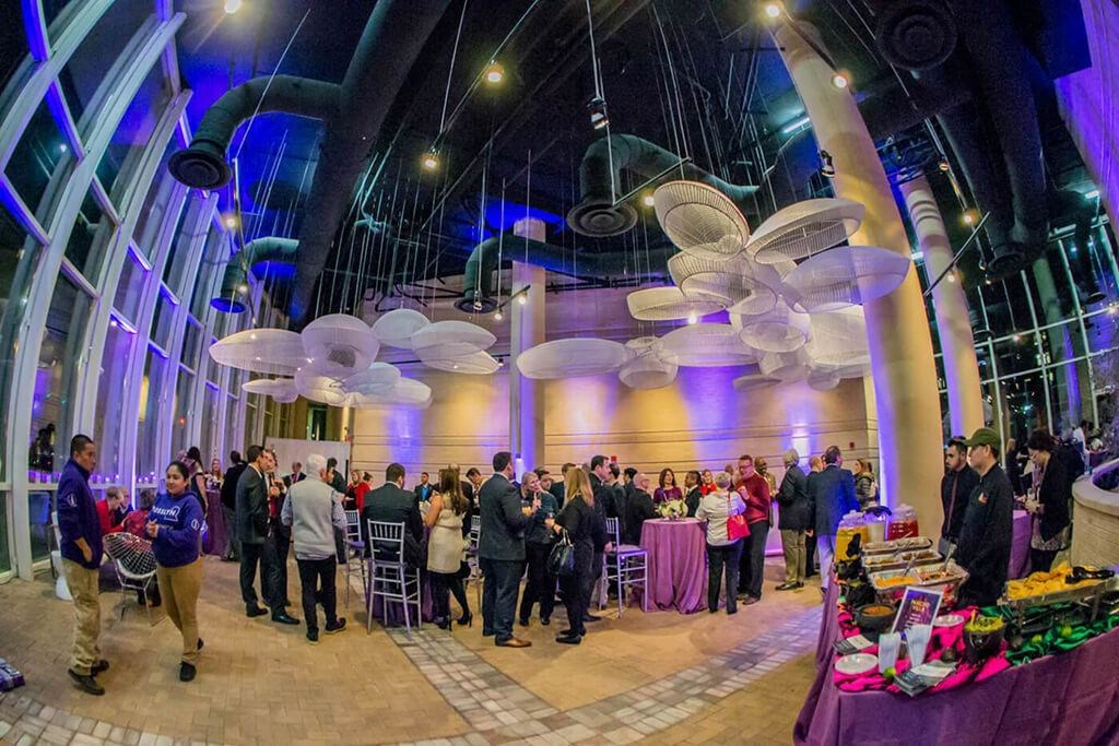 a group of people standing in a room with balloons