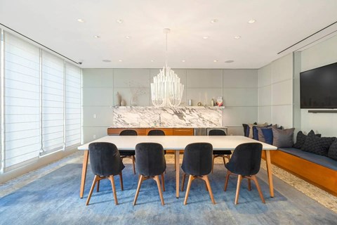 A modern dining room with a large table and chairs.