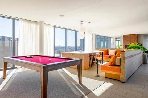 A pool table in a room with a view of the city.