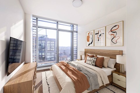 A bedroom with a large bed and a flat screen TV.