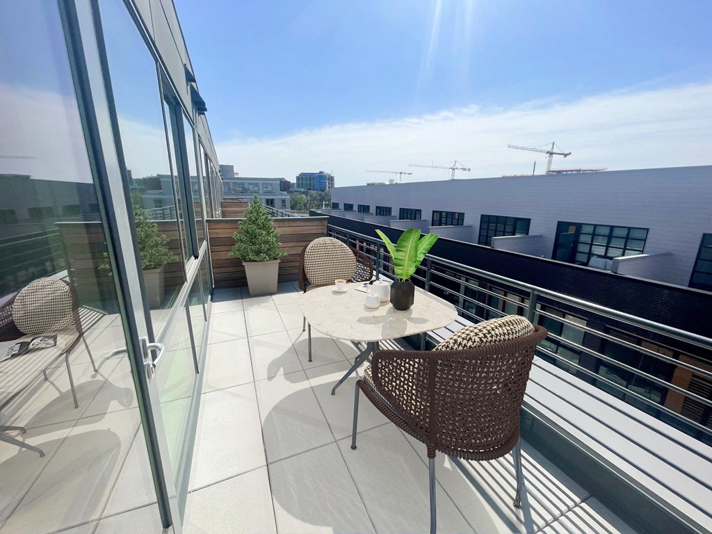 a terrace with a table and chairs on a balcony