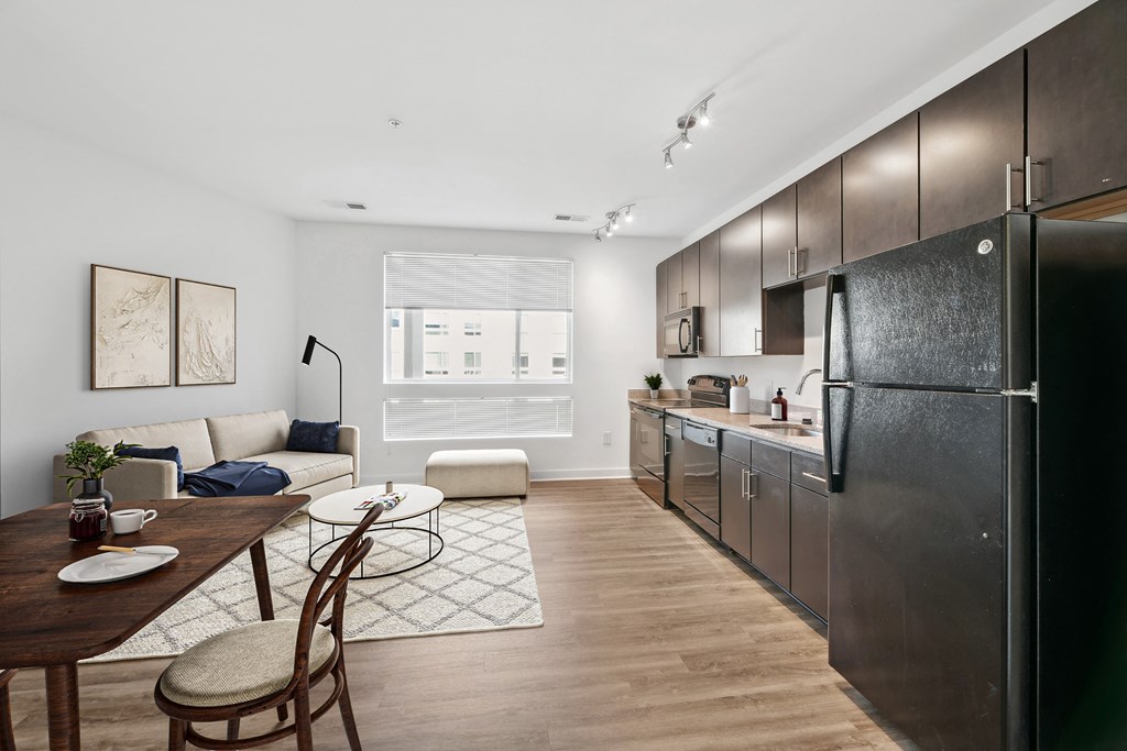 a kitchen and living room with a refrigerator and a table