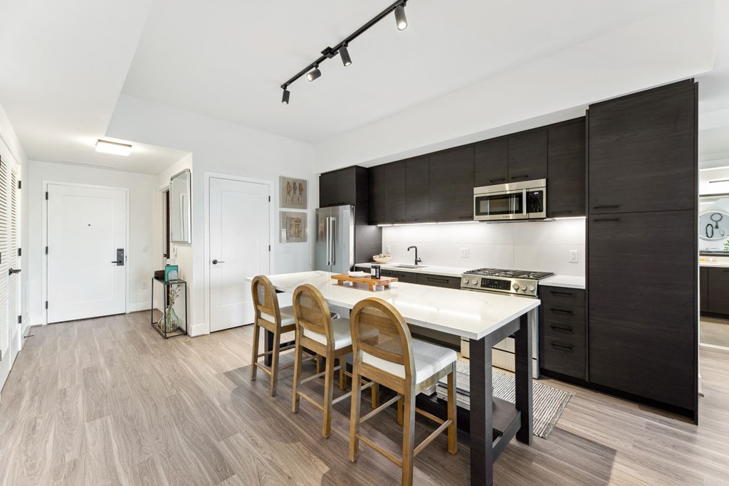 a kitchen with a white island and wooden chairs