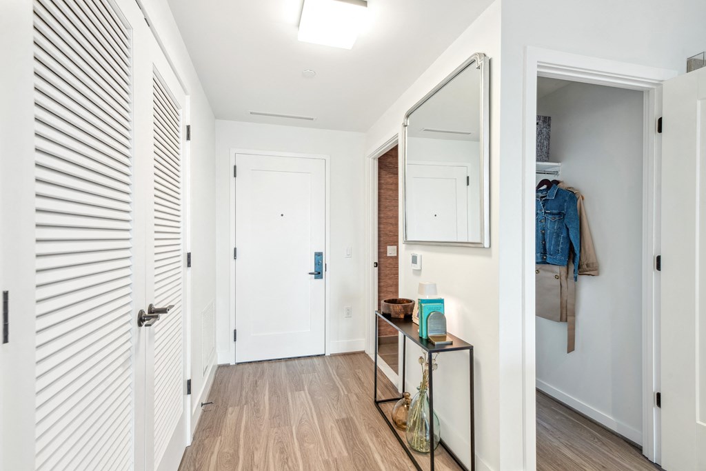 a hallway with a door to a closet and a mirror