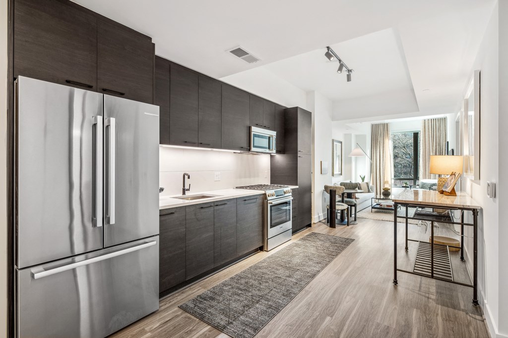 a kitchen with stainless steel appliances and wooden floors